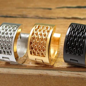 Könnte beinhalten: Drei Creolen mit einem Kettenglied-Design. Die Ohrringe sind silber, gold und schwarz.