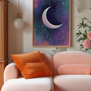 May include: A framed print of a crescent moon with a gold outline against a dark blue background with gold stars. The background is a watercolour wash of pink, purple, and green.