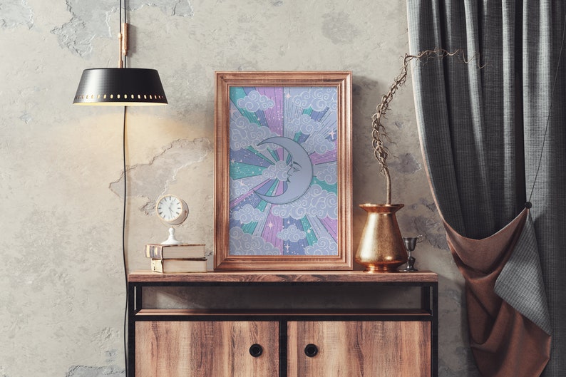 May include: A framed print with a crescent moon and stars on a rainbow background. The print is in a wooden frame and is hanging on a wall above a wooden cabinet.