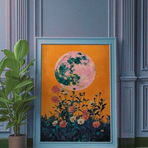 May include: A framed print of a pink and green moon with a yellow background and a field of flowers in the foreground.