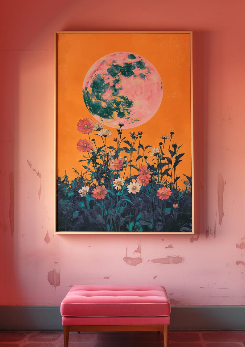 May include: A framed print of a pink and green moon with a field of flowers in the foreground. The background is a bright orange color.