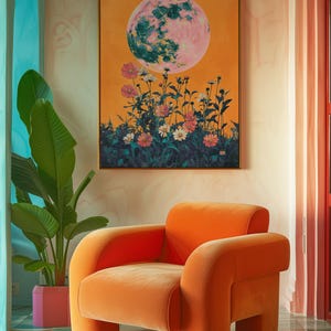 May include: A bright orange velvet armchair with rounded edges sits in a room with a large painting of a pink moon and flowers. The room has a teal and white tiled floor.