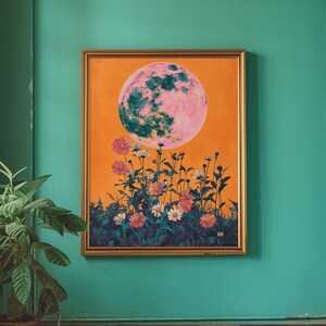 May include: A framed painting with an orange background featuring a large pink and green moon with a field of flowers in the foreground.