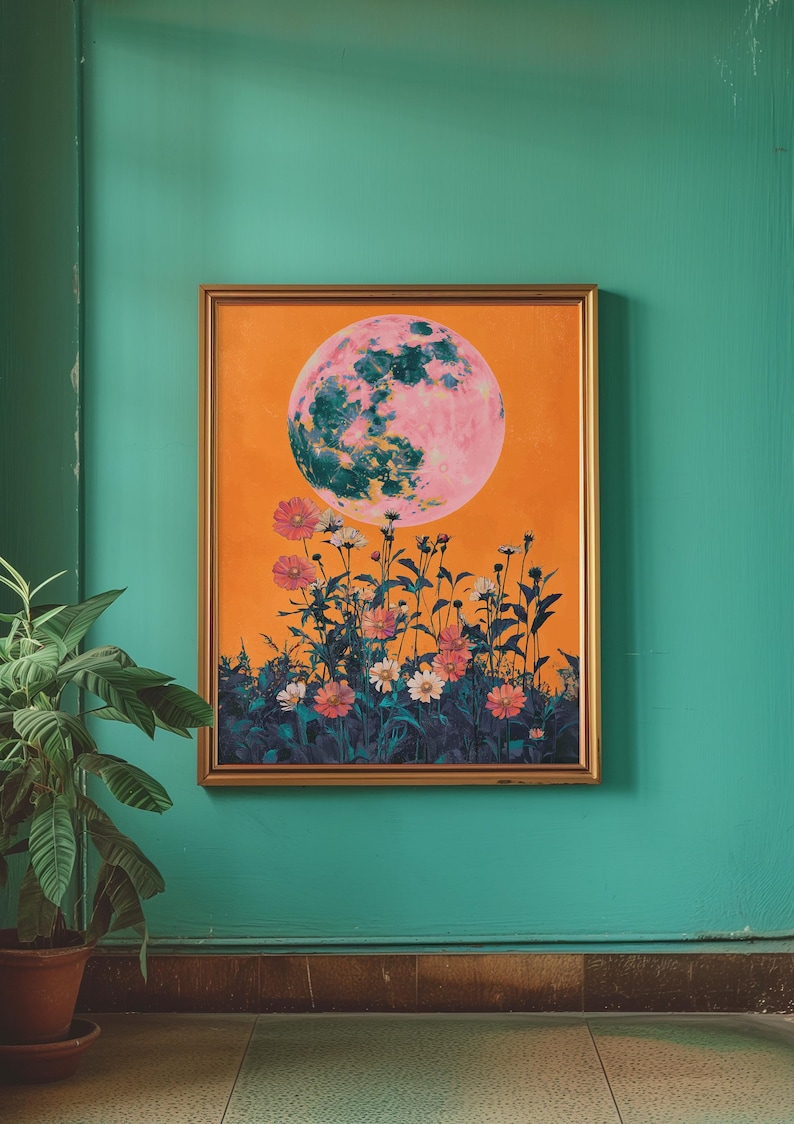 May include: A framed painting with an orange background featuring a large pink and green moon with a field of flowers in the foreground.
