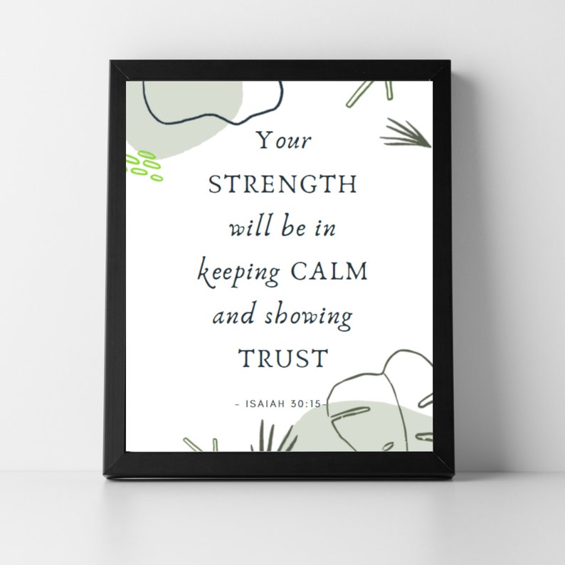 May include: A framed print with the text "Your strength will be in keeping calm and showing trust." The print has a white background with green and black decorative elements. The frame is black.