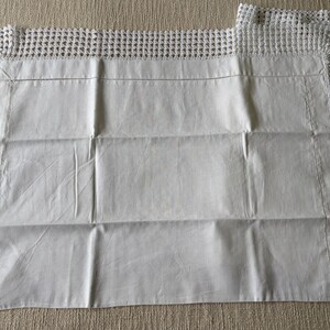 K&ouml;nnte beinhalten: Wei&szlig;e Kissenbez&uuml;ge mit geh&auml;keltem Spitzenrand. Die Kissenbez&uuml;ge sind rechteckig mit einer glatten, leicht zerknitterten Textur. Der Spitzenrand verleiht der Bettw&auml;sche eine zarte, handgefertigte Note.