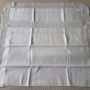 K&ouml;nnte beinhalten: Zwei wei&szlig;e, rechteckige Kissenbez&uuml;ge mit geh&auml;keltem Rand. Die Kissenbez&uuml;ge sind aus einem glatten, hellen Stoff gefertigt und haben ein schlichtes, elegantes Design. Der geh&auml;kelte Rand sorgt f&uuml;r eine besondere Textur und Detail.
