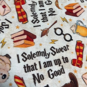 May include: White fabric with a repeating pattern of Harry Potter themed images. The images include a stack of books, a broom, a pair of glasses, a scarf, a mug, and a lightning bolt. The text "I solemnly swear that I am up to no good" is repeated throughout the fabric.