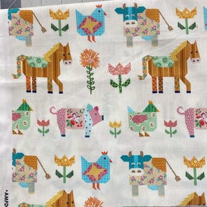 May include: White fabric featuring a repeating pattern of farm animals and flowers. The design includes horses, cows, chickens, and pigs, each with patchwork-style details. The flowers are in various colors, creating a cheerful, country-themed textile.
