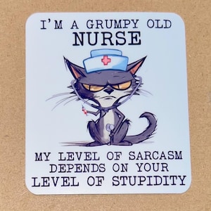 May include: A rectangular sticker with rounded corners featuring a cartoon cat dressed as a nurse. The cat has an angry expression and wears a nurse's cap and stethoscope. Text reads "I'M A GRUMPY OLD NURSE" and "MY LEVEL OF SARCASM DEPENDS ON YOUR LEVEL OF STUPIDITY."
