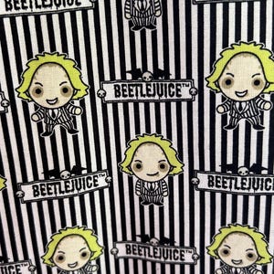 May include: Black and white striped fabric with a repeating pattern of a cartoon character with green hair and a black suit. The character is holding a skull and the text "BEETLEJUICE™" is repeated throughout the fabric.