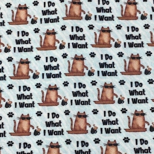 Può includere: Uno sfondo blu con un motivo ripetuto di gatti marroni che indossano occhiali da sole e tengono una tazza di caffè. Il testo "I Do What I Want" è ripetuto in tutto il motivo.