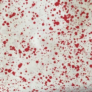 以下が含まれることがあります： 不規則な形の赤い飛沫が繰り返される白い生地。飛沫のサイズは様々で、テクスチャード加工されたダイナミックな視覚効果を生み出しています。生地は軽量素材のようです。
