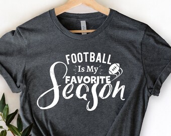 May include: A dark gray t-shirt with white text that reads "Football Is My Favorite Season" with a football graphic.