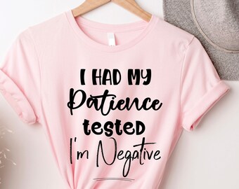 Könnte beinhalten: Rosa T-Shirt mit schwarzem Text, der "Ich hatte meine Geduld auf die Probe gestellt, ich bin negativ" lautet.