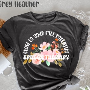 May include: Dark grey heather t-shirt with a floral design and the text "Grow to your full potential Speech Therapy".