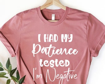Könnte beinhalten: Heather-mauvefarbenes T-Shirt mit dem Text "I had my patience tested I'm negative" in Weiß.