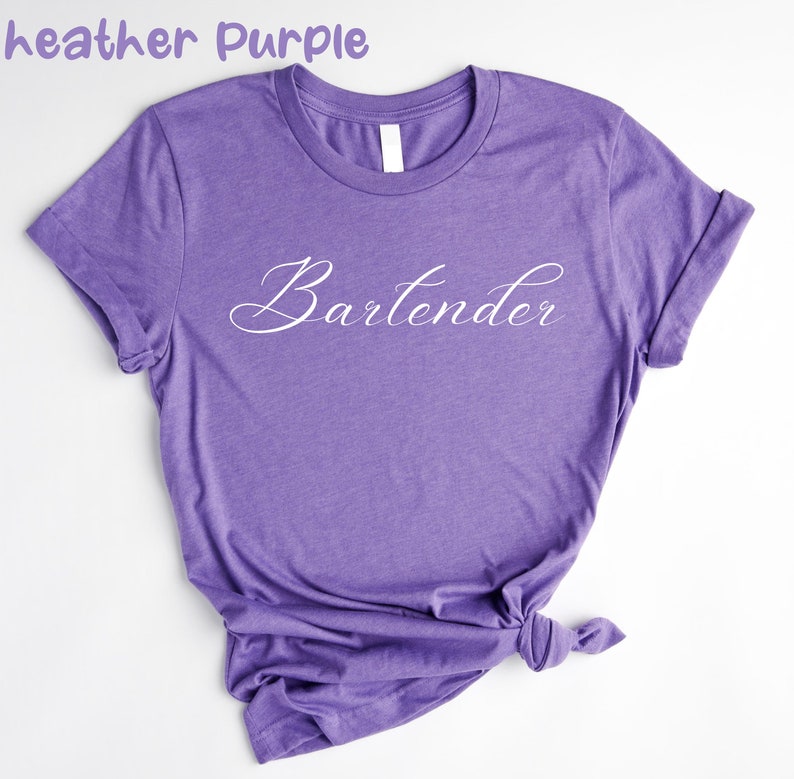 May include: A heather purple t-shirt with the word "Bartender" written in white cursive script.