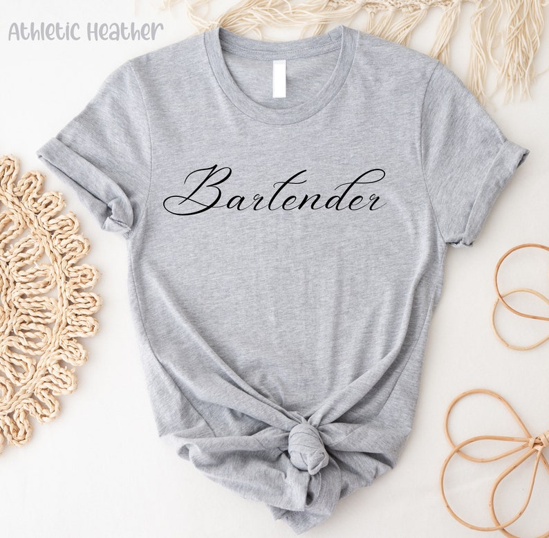 May include: A gray t-shirt with the word "Bartender" written in black cursive script.