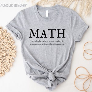 May include: Gray t-shirt with the text "MATH" and the phrase "the only place where people can buy 87 watermelons and nobody wonders why."