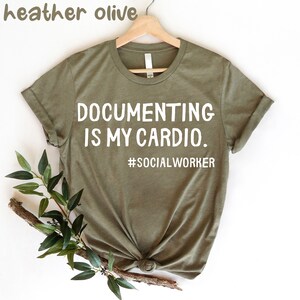 May include: A green t-shirt with the text "DOCUMENTING IS MY CARDIO. #SOCIALWORKER" printed in white.
