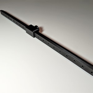 May include: A black metal tool with a rectangular body and a series of evenly spaced holes. A connecting piece with a knob is attached to the body. The tool is designed for precision and measurement.