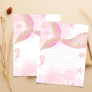May include: Two pink and gold mermaid tail stationery sheets with lined writing space. The sheets feature a pink mermaid tail with gold glitter, seahorse illustrations, and a watercolor background.