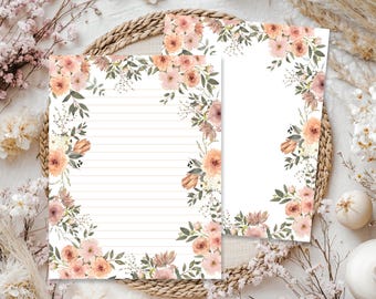May include: Two rectangular sheets of stationery featuring a floral border design. One sheet contains horizontal lines for writing, while the other is blank. Both sheets are decorated with watercolor-style peach and pink flowers and green leaves.