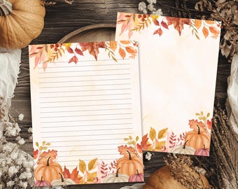 May include: Two sheets of stationery paper featuring watercolor illustrations of autumn leaves and pumpkins. One sheet contains horizontal lines for writing, while the other is blank. Both pages have decorative borders with orange, red, and yellow foliage.