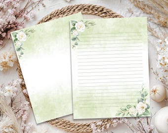 May include: Two sheets of stationery paper featuring a soft green watercolor wash background. One sheet is blank, while the other contains horizontal lines. Both sheets are decorated with white rose illustrations and green leaves in the corners.