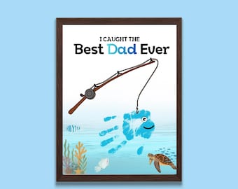 May include: Framed art print with the text "I Caught the Best Dad Ever." The artwork features a fishing rod, a blue handprint fish, and underwater elements like a turtle and coral.