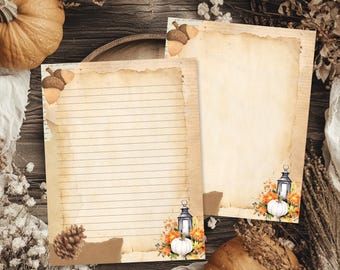 May include: Two sheets of stationery paper with a vintage parchment appearance. One sheet features horizontal lines, while the other is blank. Both are decorated with autumn-themed illustrations including acorns, pinecones, lanterns, and pumpkins.