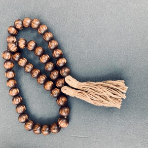 Rustic Espresso Wood Bead Strand with Carved Details and Earthy Jute Tassels