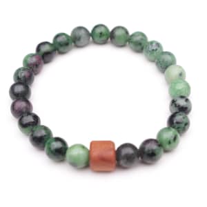 May include: A beaded bracelet featuring round, polished stones in shades of mottled green, black, and deep magenta. The circular strand is accented by a single, smooth, rectangular wooden bead in a warm, reddish-brown tone.