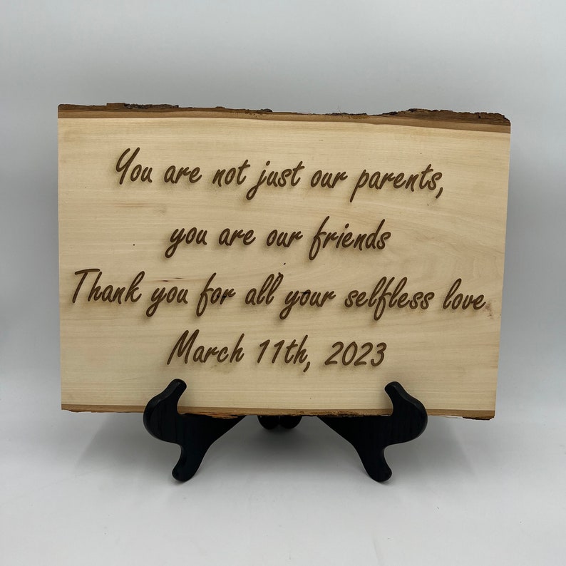 Puede incluir: Un letrero de madera con el texto "You are not just our parents, you are our friends. Thank you for all your selfless love. March 11th, 2023."