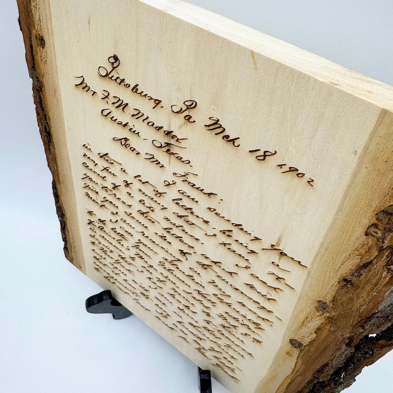 May include: A rectangular light-colored wooden plaque with natural bark edges featuring a laser-engraved handwritten letter dated March 18, 1902, from Pittsburg, Pa. The text is dark brown and legible, set against the smooth, pale grain of the wood.