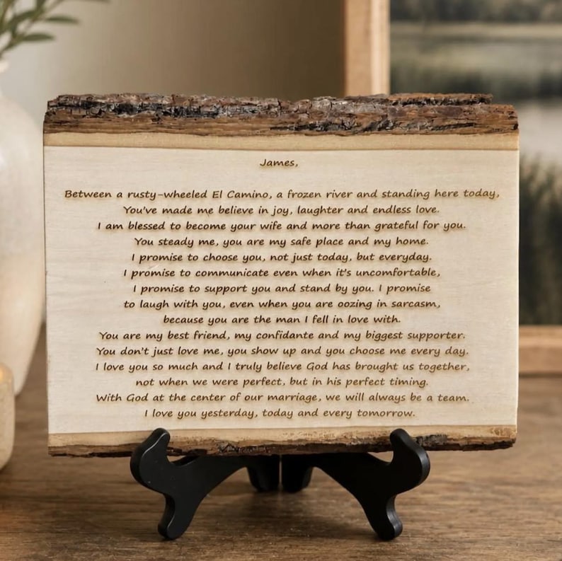 May include: A rectangular wooden plaque with natural bark edges, displayed on a black plastic stand. The light-colored wood surface features dark engraved text beginning with 'James,' followed by a personal letter expressing love and commitment.