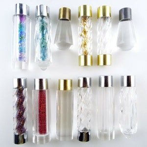 May include: Assortment of 12 clear glass drawer pulls with various coloured beads and finishes. The pulls have a variety of designs, including twisted, clear, and beaded.