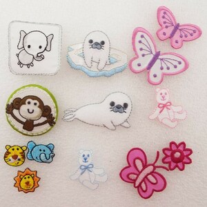 May include: A set of 10 iron-on patches featuring various animal and nature designs. The patches include a monkey, elephant, seal, butterfly, flower, and teddy bear. The patches are all colourful and detailed.