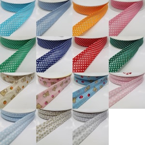 May include: Assortment of 12 rolls of elastic trim with various polka dot and printed patterns. The patterns include blue polka dots, green polka dots, navy blue polka dots, red polka dots, pink polka dots, light blue polka dots, beige polka dots, light grey polka dots, a beige background with brown teddy bears and strawberries, a light blue background with brown teddy bears and strawberries, a pink background with brown teddy bears and strawberries, and a beige background with brown teddy bears and strawberries.