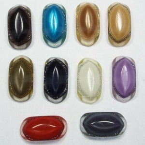 May include: Ten assorted oval-shaped buttons with a raised centre and a sparkly finish. The buttons are in various colours, including blue, brown, gold, green, purple, red, and white.