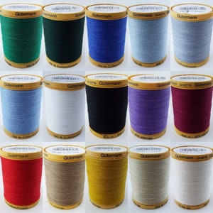 May include: A collection of 12 spools of Gutermann thread in various colours, including green, blue, white, black, purple, red, orange, and beige. Each spool is labelled with the Gutermann brand name and the thread colour.