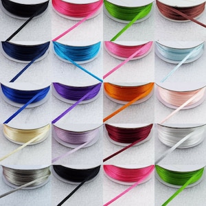 May include: Assortment of 16 spools of satin ribbon in various colours, including navy blue, pink, green, turquoise, purple, orange, light pink, cream, lavender, burgundy, white, grey, black, hot pink, lime green, and silver.