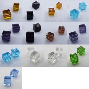 May include: Assortment of 10 pairs of square glass beads in various colours, including clear, black, blue, green, purple, and brown. The beads have a faceted design and are ideal for jewellery making.