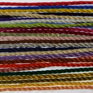 May include: A collection of 30 different colours of twisted cord, each approximately 10 inches long. The cords are arranged in rows, with each row featuring a different colour.