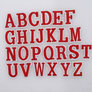 May include: Red felt alphabet letters with white outlines. The letters are arranged in alphabetical order from A to Z.