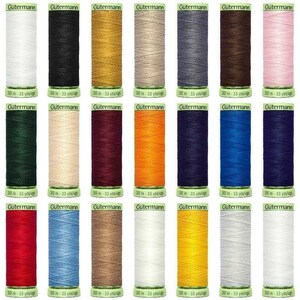 May include: A collection of 24 spools of Gütermann thread in various colours, including white, black, gold, beige, grey, brown, pink, green, orange, red, blue, and yellow. Each spool is labelled with the brand name "Gütermann" and the length of the thread in yards.