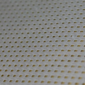 May include: A white fabric with a grid pattern of small, gold squares.