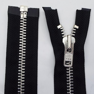 May include: A black zipper with a silver metal slider and teeth. The zipper is open and the slider has the text "YKK" on it.