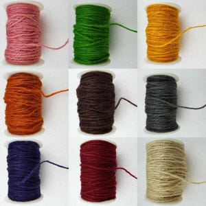 May include: Nine spools of twine in various colours, including pink, green, yellow, orange, brown, grey, blue, red, and beige. The spools are all the same size and are arranged in a grid pattern.